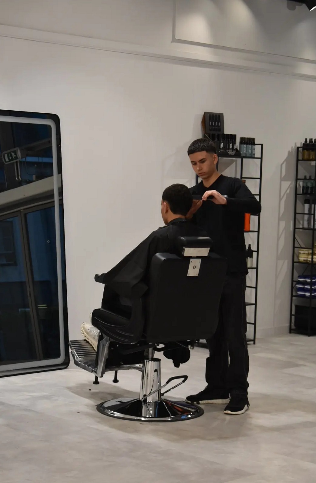 Barber knipt een klant in de zwarte barberstoel